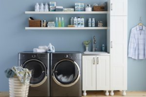 A laundry room with an energy-efficient washer and dryer and shelves containing Amway Home care products. Even with biodegradable, phosphate-free laundry and home cleaning formulas that perform as well as or better than typical products, Amway scientists keep working to improve them!