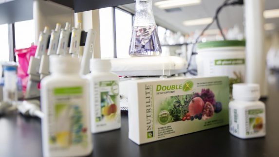 Packaged Nutrilite supplements on a counter in Amway's Research and Development lab. Supplement stability tests are conducted on every product and package, guaranteeing effectiveness and tablet shelf life through the expiration date listed on the package.