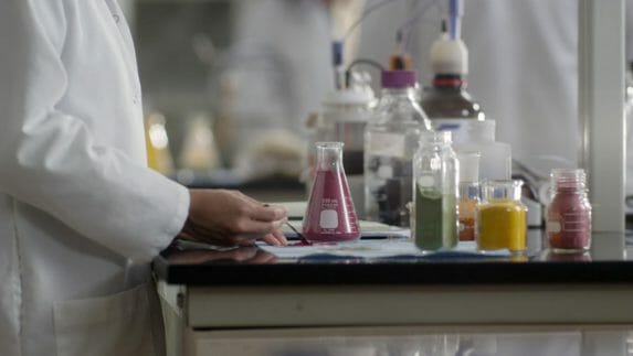 Lab worker working with different color powders