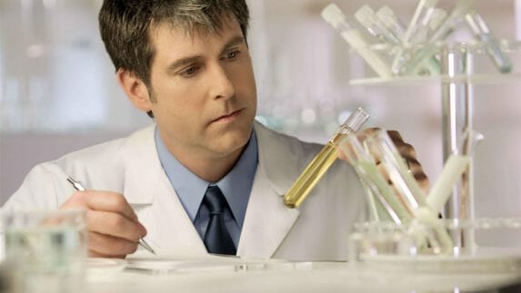 Scientist examining fluid in test tube