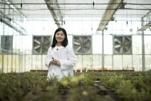 A female scientist stands among the plants in the Amway Botanical Research Center greenhouse. There are said to be thousands of plants used in Traditional Chinese Medicine. The ABRC has established a library of plant resources to catalog each plant species by its benefit and edible value. As useful plants are discovered, they will be grown in larger fields for more in-depth study.