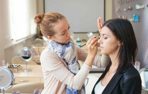 woman applying makeup on another person