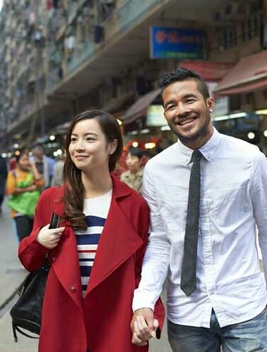 Two people walking down the street hand in hand