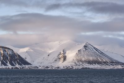 Snowy mountains viewed from the water in Bildudalur, Iceland