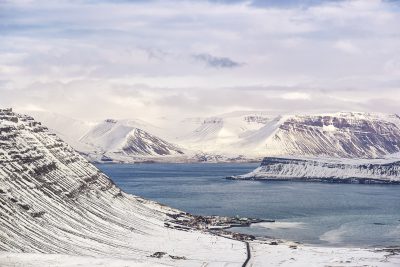 Lake surrounded by large snowy hills