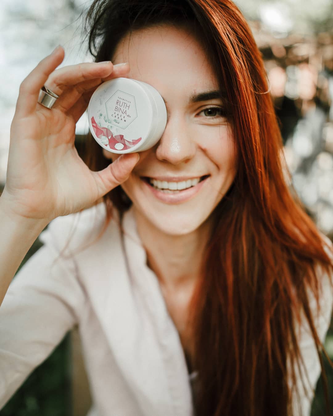 Woman holding Ruth Bina puck in front of her eye