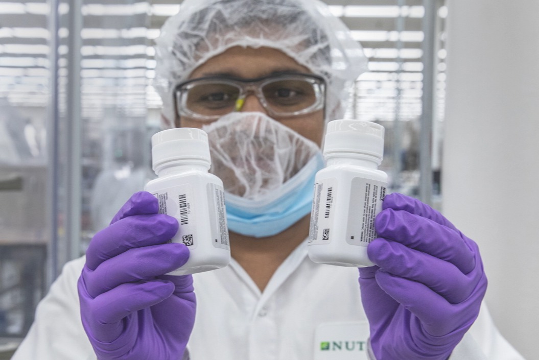 Nutrilite worker holding bottles of products