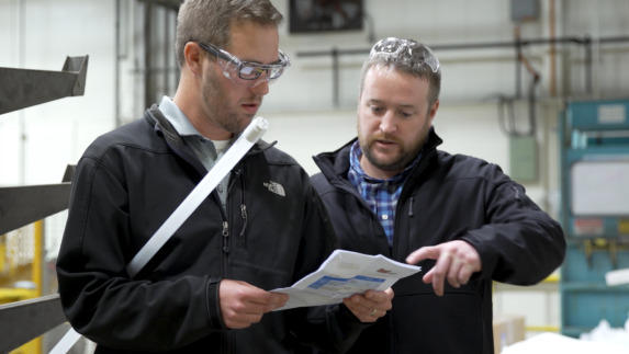 two members of Amway's facilities team reviewing plans