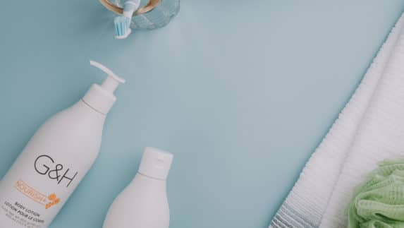 A flat lay image of a bathroom counter with G&H Nourish body lotion and body wash, a toothbrush holder with Glister toothbrushes and a box with Glister toothpaste next to a towel and body scrubber. We infuse plant nutrients, called phytonutrients, into our products to provide a wide range of health benefits. Many of these plants are grown on our own certified organic farmlands.