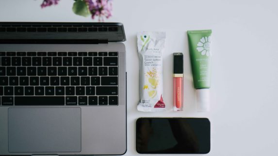 Flat lay with Sweet Lemon Crunch BodyKey bar, Artistry Light Up Lip Gloss, Artistry essentials Light Lotion near an open laptop and a smart phone. This image is from one of the monthly downloadable packages of photos for our business owners to use on social media, whether that’s WeChat or Facebook, Instagram or Line.