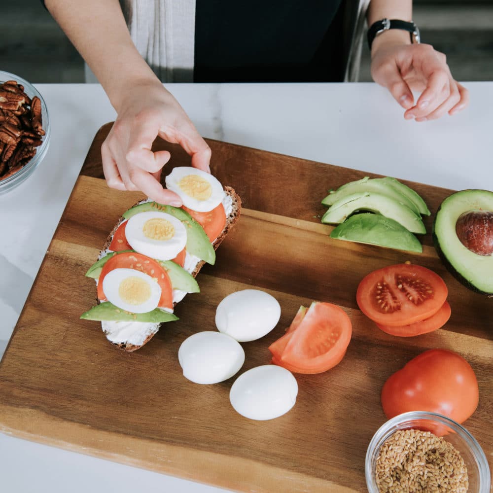 girl making avocado egg toast