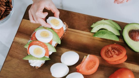 girl making avocado egg toast