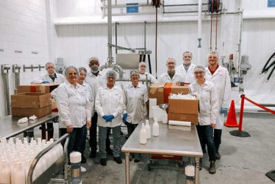 Amway employees wearing hairnets prepare products to donate