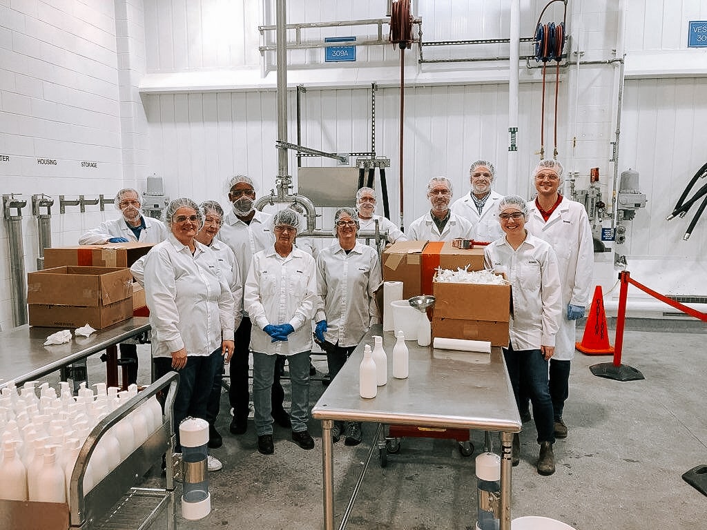 Amway employees wearing hairnets prepare products to donate