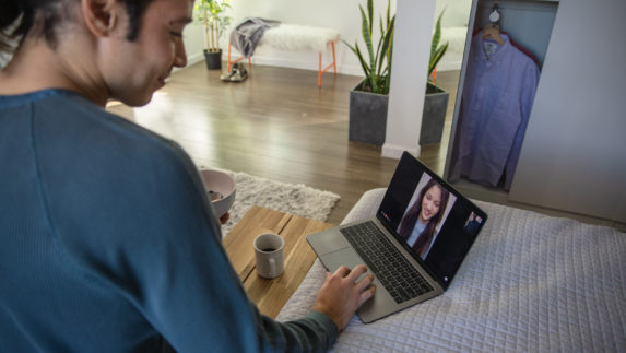 Man chats with a woman over video call on a laptop