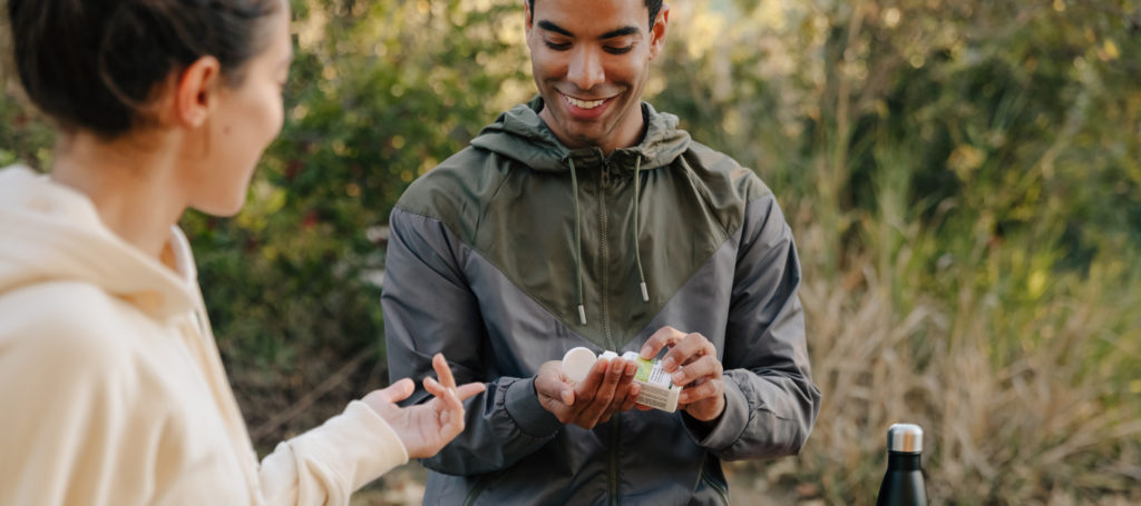 Two people taking vitamins outside