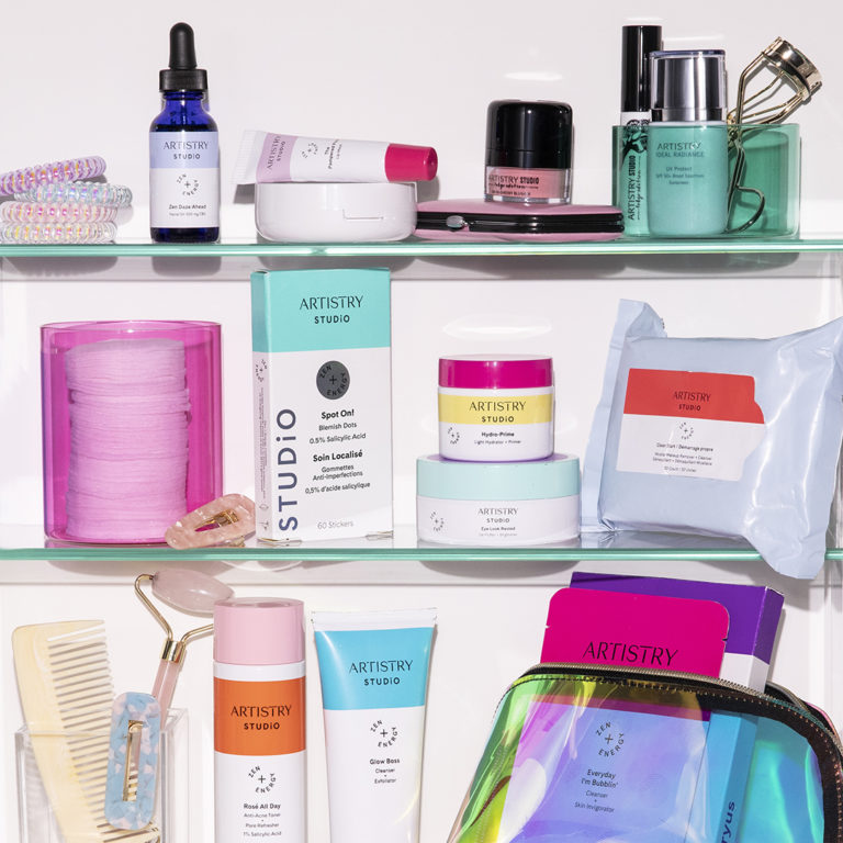 Close up of three shelves filled with an array of 14 different artistry studio products and other bathroom type accessories