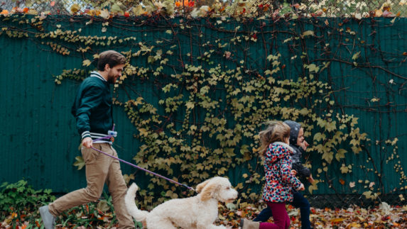 Man and children walking a dog