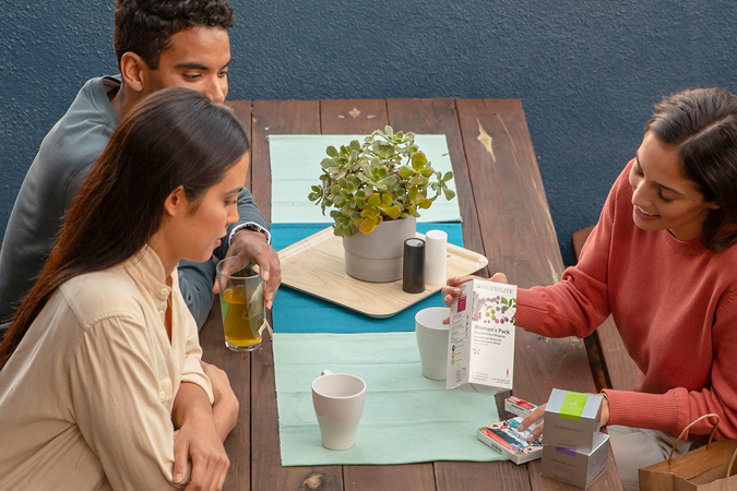 Amway Business Owners sitting at a table and showing product