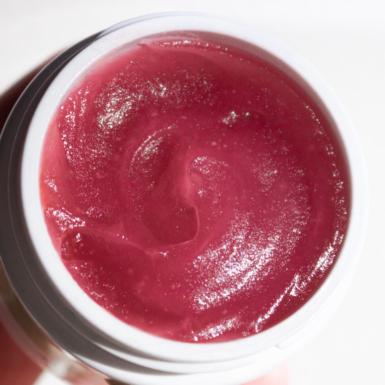 Open jar of an artistry studio product that is a deep red