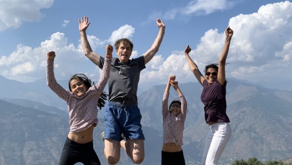Four people jumping with their hands in the air