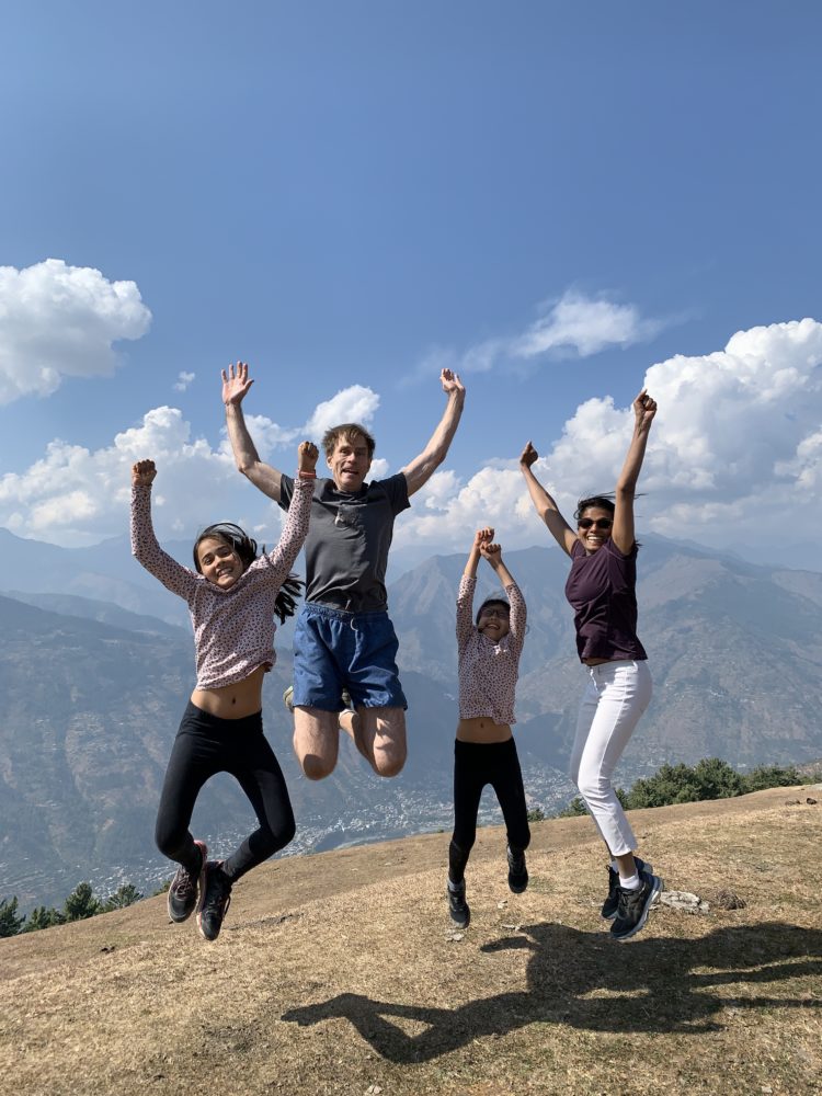 Four people jumping with their hands in the air