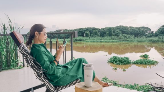 Woman sitting by lake with Bodykey bottle next to her