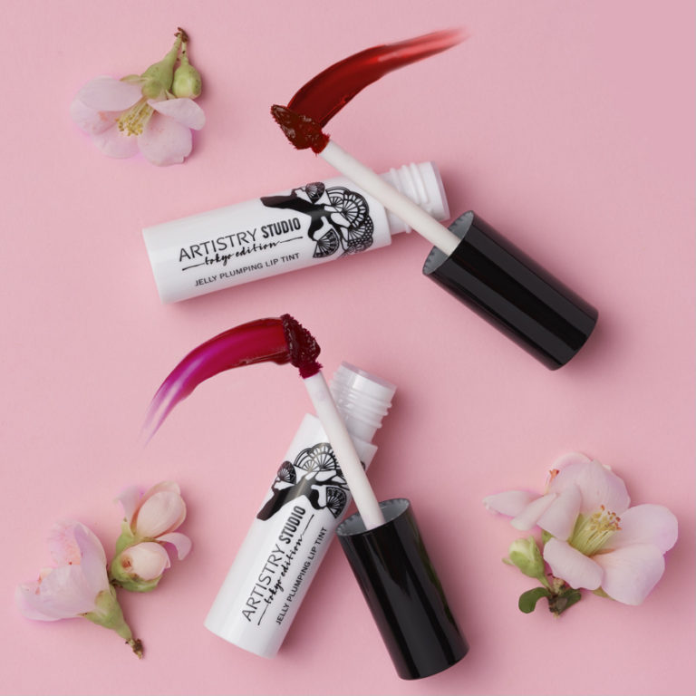 Two Artistry Studio Tokyo Edition jelly plumping lip tints swatched on a pink backdrop with cherry blossoms