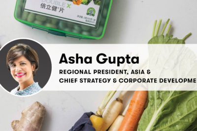 Asha Gupta headshot and title over background of vegetables and vitamins