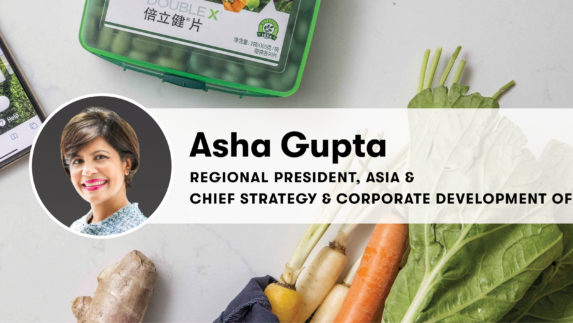 Asha Gupta headshot and title over background of vegetables and vitamins