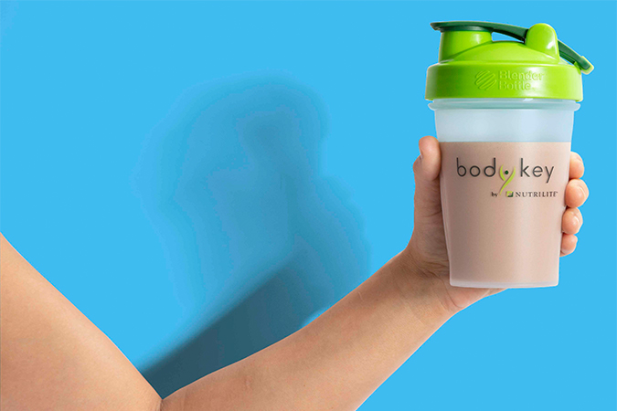 Hand holding a Bodykey by Nutrilite bottle