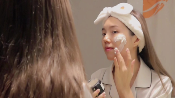 Woman applies cosmetic product to her face