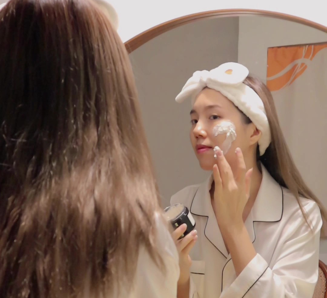 Woman applies cosmetic product to her face