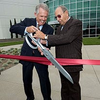 Two men cutting ribbon