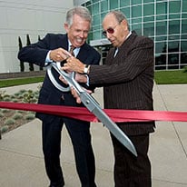 Two men cutting ribbon